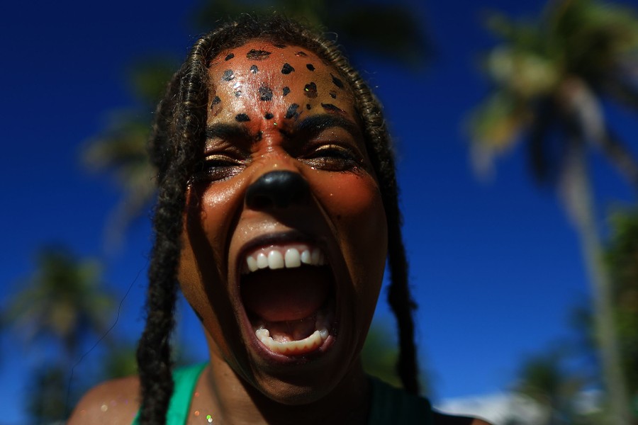 A person with playful animal makeup roars toward the camera.
