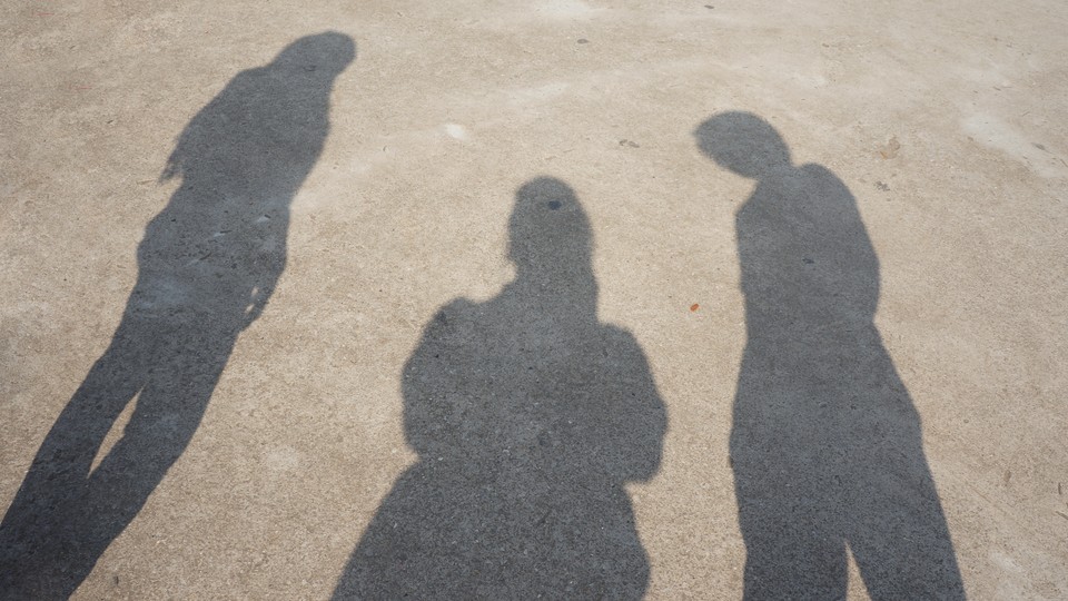 The shadows of three figures on the ground