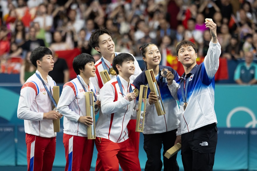 The six top mixed-doubles Olympic table-tennis players pose for a selfie during the medal ceremony.