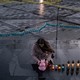 A woman leans over at a candlelight vigil for Ukrainians killed in the towns of Bucha and Irpin.