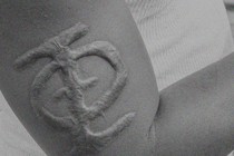 A man's arm with a branded fraternity symbol