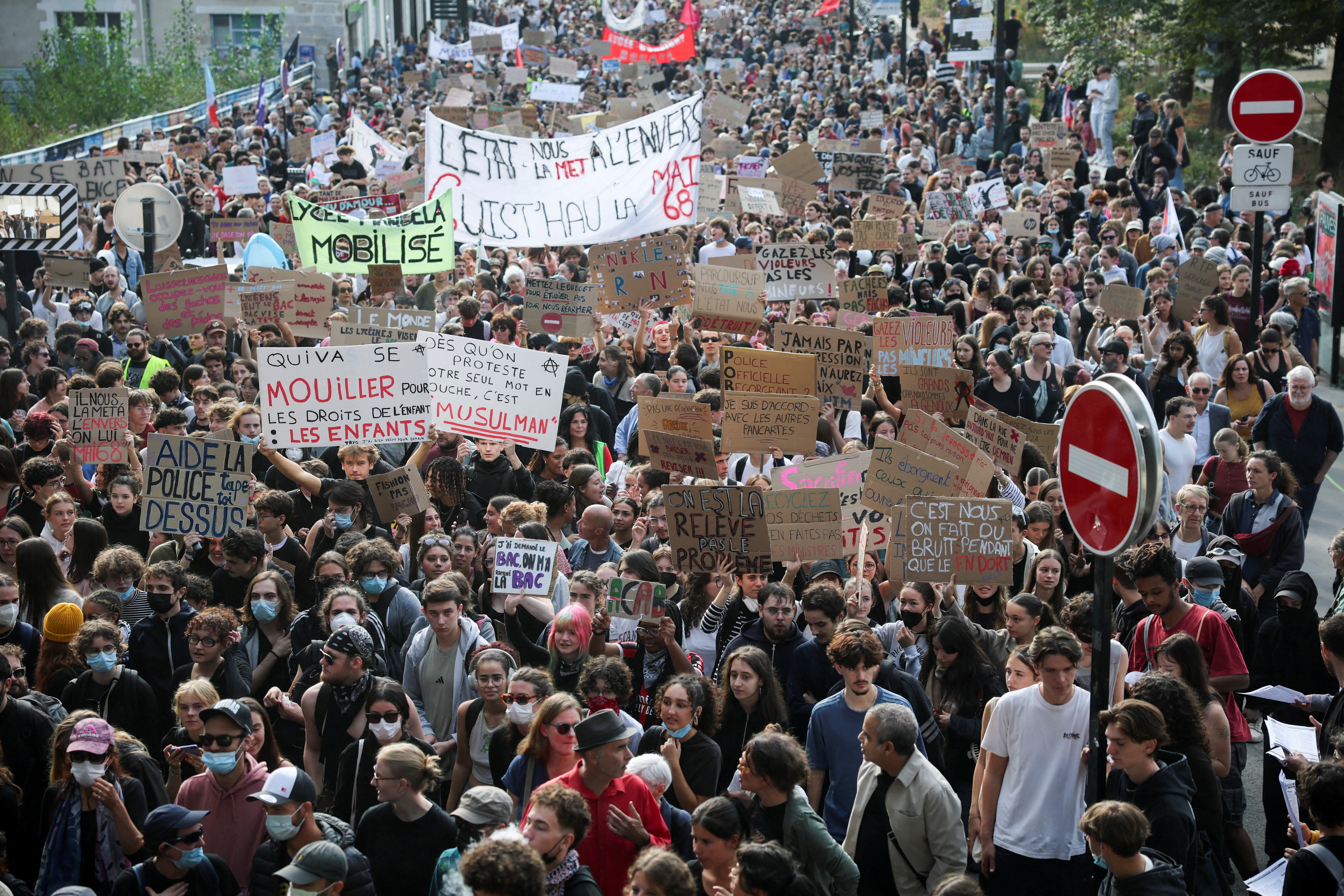 A large crowd of protesting students carrying many hand-made signs
