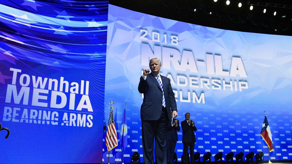 President Trump stands on a stage at the NRA convention.