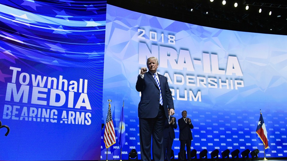 President Trump stands on a stage at the NRA convention. 