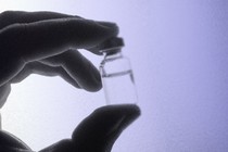 a hand holds a vial