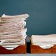 A photo of two stacks of paper, one short and one tall