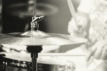 A black and white photo of a senior person playing the drums