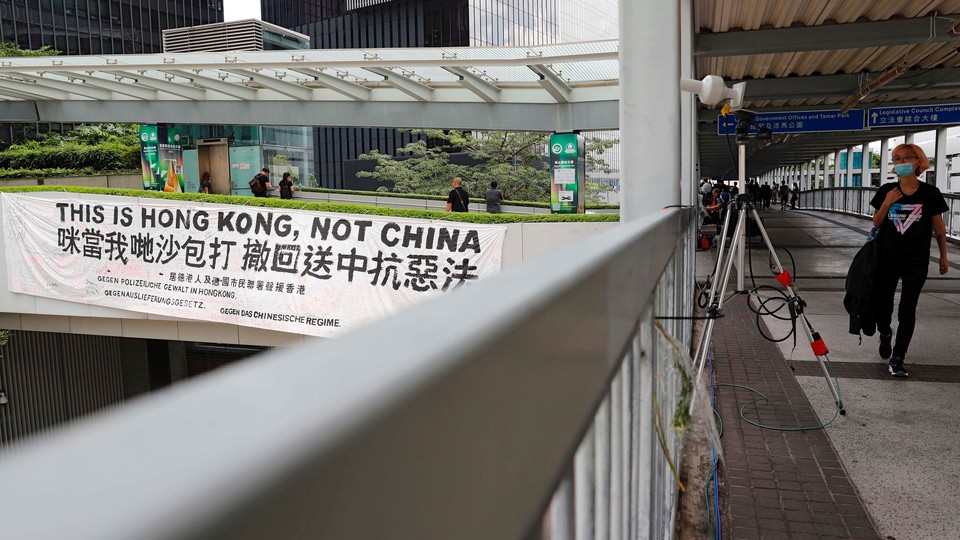 A protester walks past a banner that reads, "This is Hong Kong, not China."