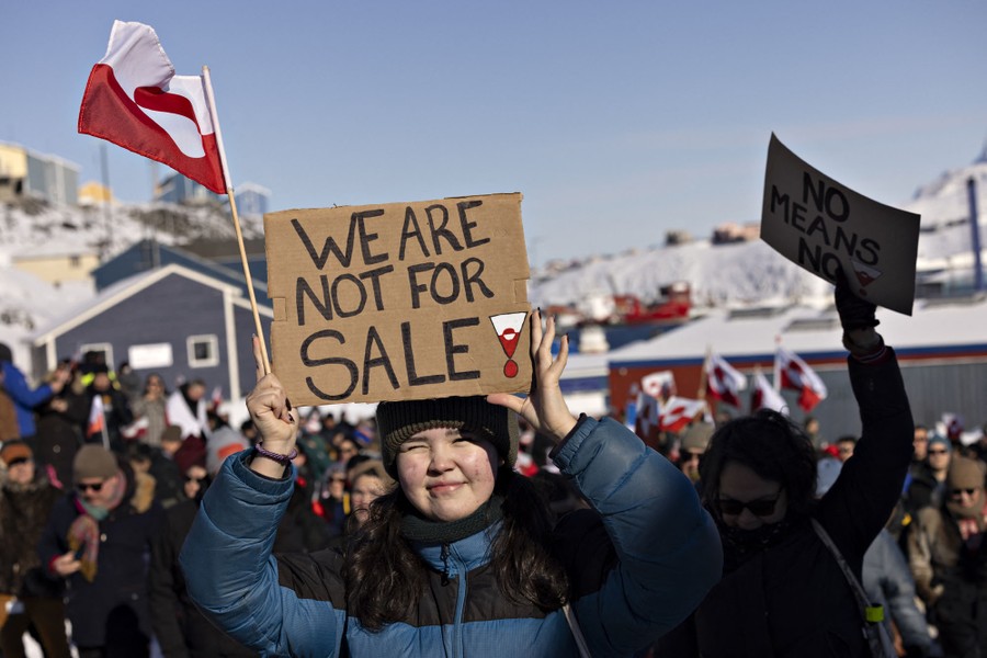 A protester holds a sign reading "We are not for sale," among other demonstrators.