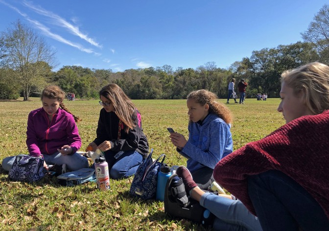 Carly, Georgia, Reagan, and Amelia sit together at a picnic for school.