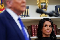 Tulsi Gabbard looks to the side at Donald Trump
