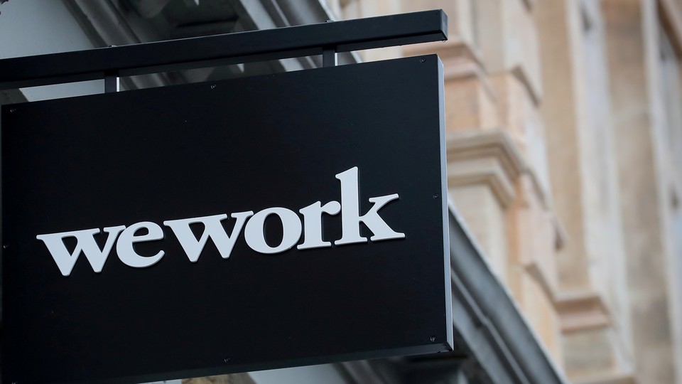 A WeWork sign against some tan buildings