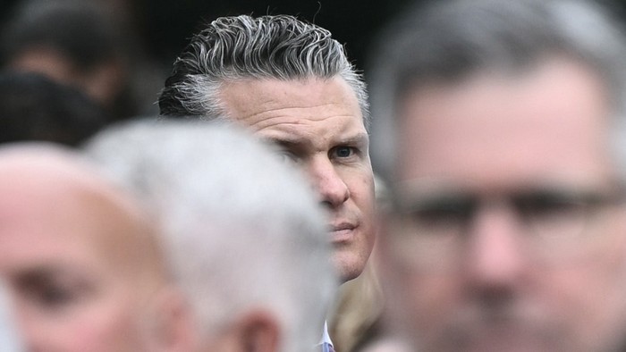 Pete Hegseth looks off to the side