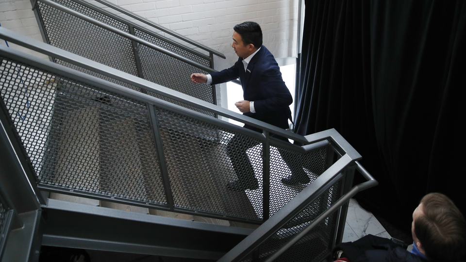 Photograph of Andrew Yang briskly walking up a staircase
