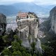 A Greek monastery, perched atop a narrow rock spire with steep cliffs all around.