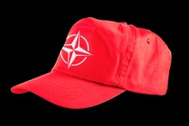 A red baseball cap with the NATO insignia on the front