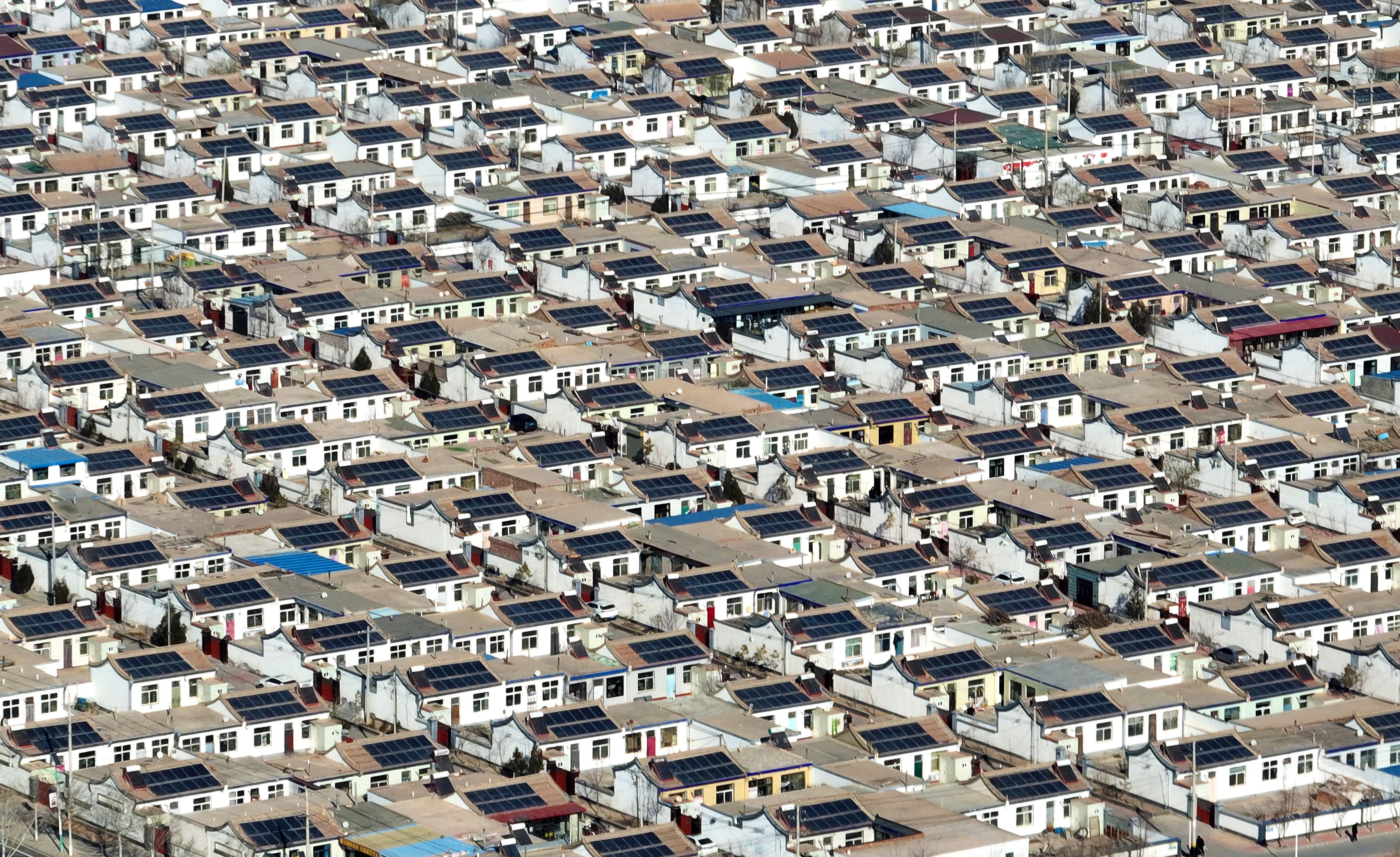 Photovoltaic panels cover the roofs of many houses in a residential development.