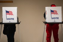 Two voters stand at polling booths