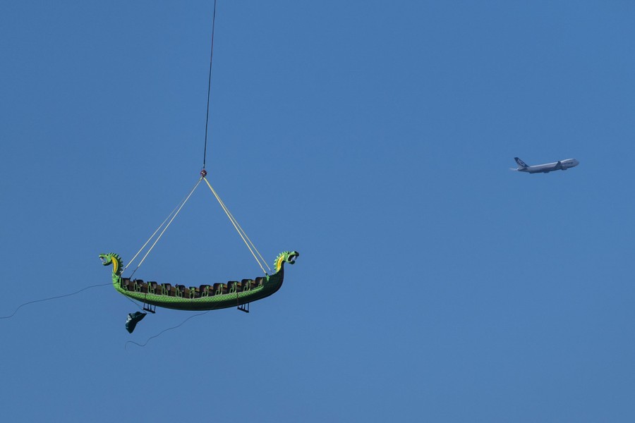 An amusement park ride is lifted by a helicopter.