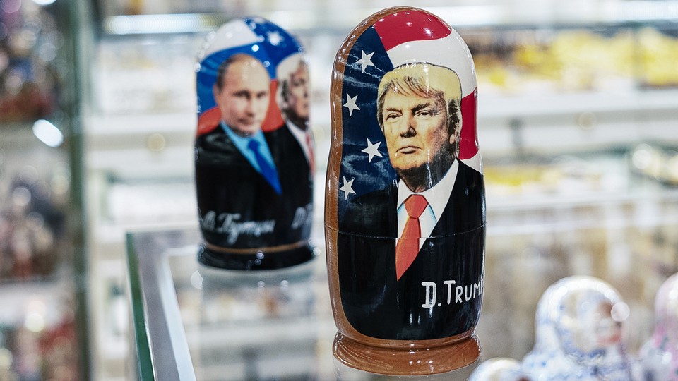 A souvenir shopkeeper displays Matryoshka dolls featuring Russian President Vladimir Putin and US presidents, including Donald Trump, on December 3, 2019 in Moscow, Russia.