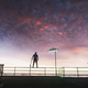 Digger Rockwell standing on metal railing holding a shovel against an ominous purple, dark sky.
