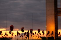 A man walks past masks in Brasilia. 