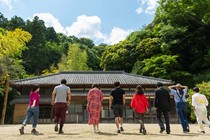 Eight adults walking toward a house in Japan