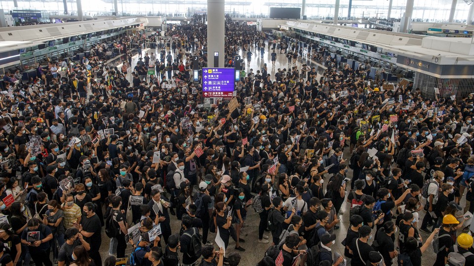 Protesters wearing black T-shirts crowd the departures hall of Hong Kong's international airport.