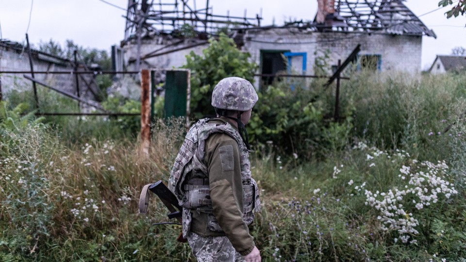 A Ukrainian soldier walks through the ruins of a village on the frontline in Lugansk oblast, Ukraine
