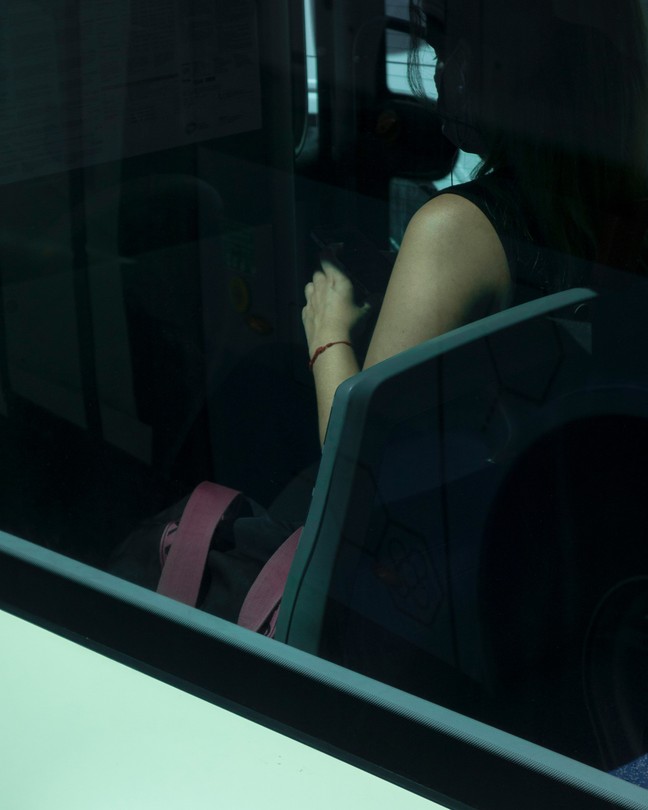 photo of a woman on the bus from outside the window