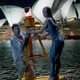 a man and a woman cling to a buoy in the ocean in front of the sydney opera house