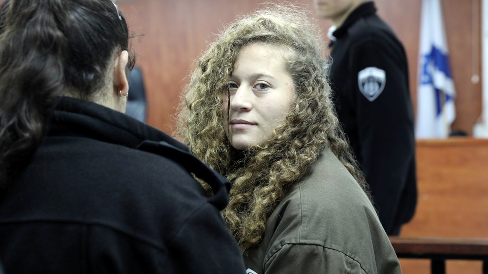 Palestinian teenager Ahed Tamimi enters a military courtroom escorted by Israeli authorities at Ofer Prison, near the West Bank city of Ramallah, on January 1, 2018.