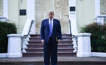 Donald Trump stands in front of a church holding a Bible