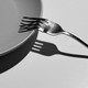 A fork breaking against a plate