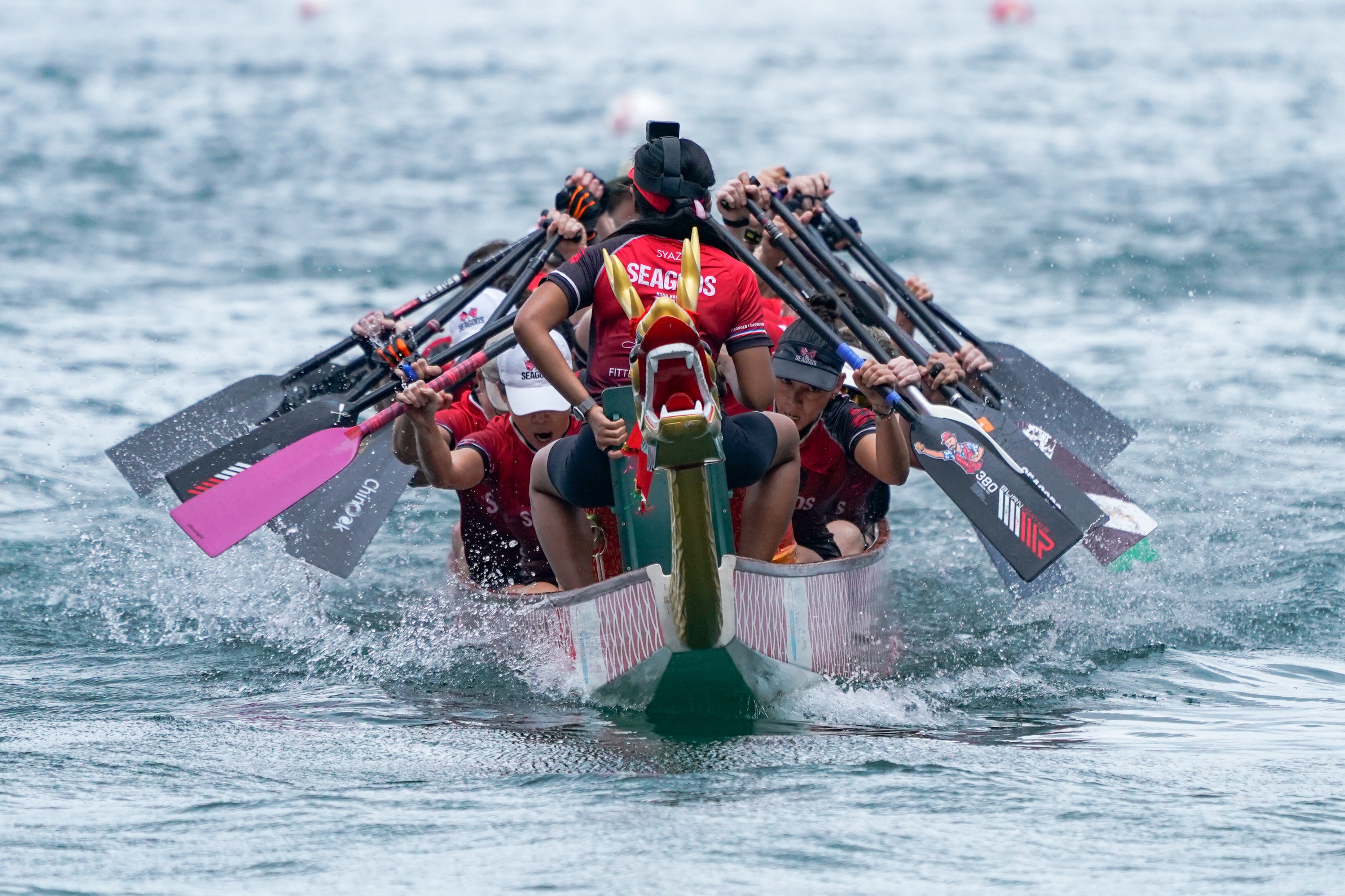 A dragon boat team rows in a race.