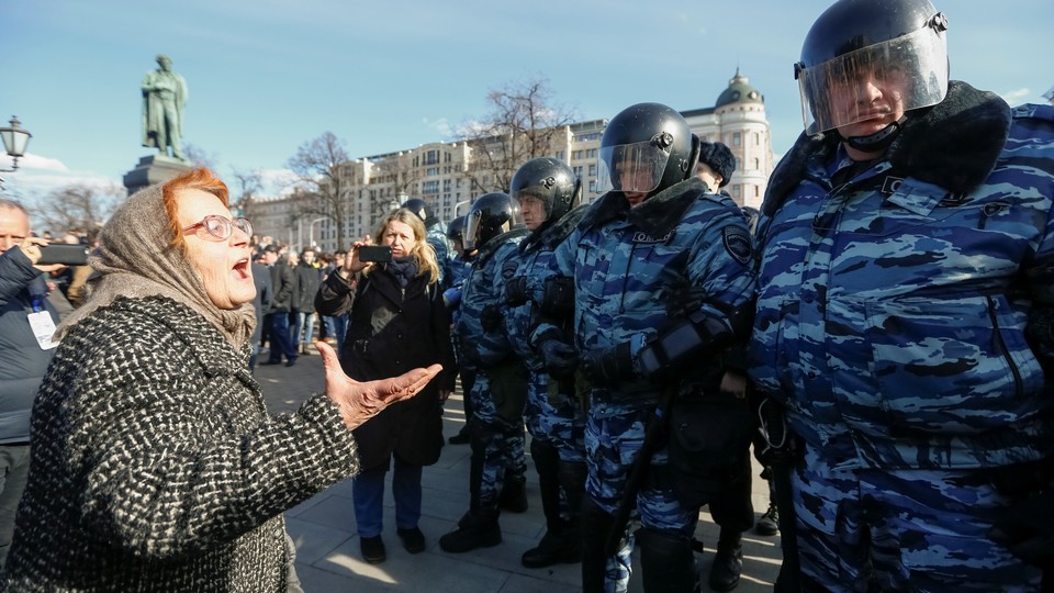 A woman argues with law enforcement officers as they block a rally in Moscow.