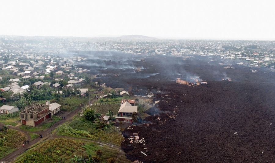 An aerial view shows the lava flow among village houses.