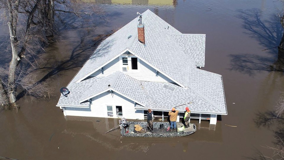 Muddy Paws Second Chance Rescue enters a flooded house to pull out several cats near Glenwood, Iowa, on March 18.
