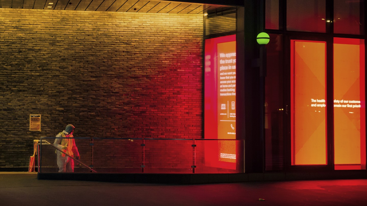 A masked worker cleans a New York City subway entrance