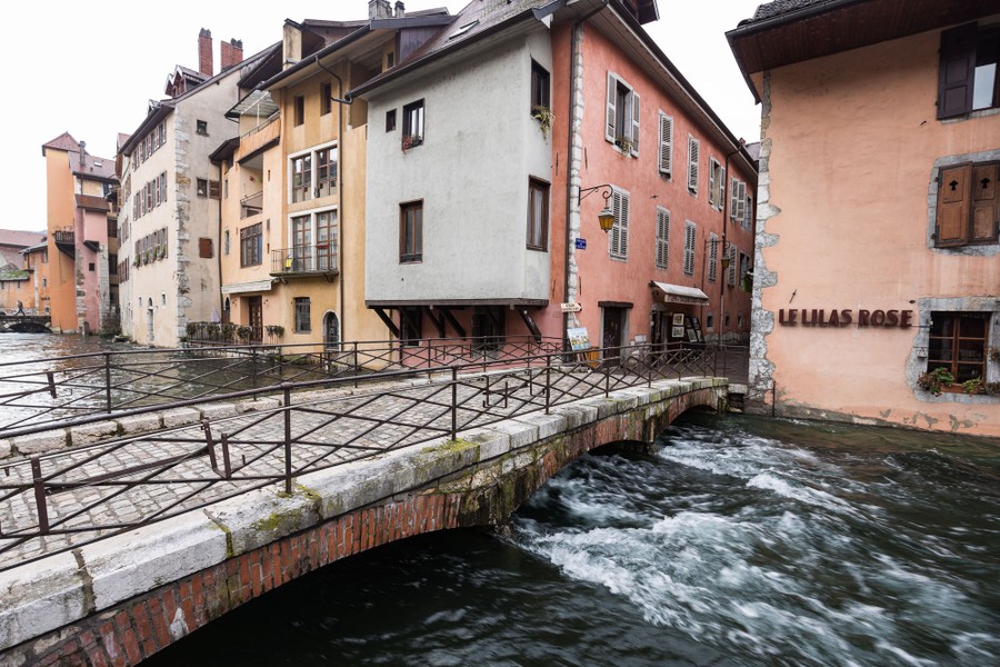 Water flows under a bridge very close to flooding it.