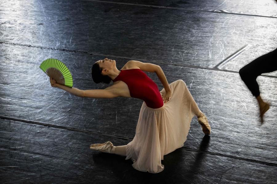 A dancer strikes a pose on one knee during a rehearsal.