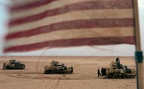 A photograph of tanks with an American flag in the foreground