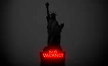 The Statue of Liberty, with a "No Vacancy" neon sign on the pedestal