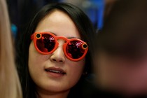 A woman wears bright red Snapchat Spectacles, glasses made by the popular app, on the floor of the New York Stock Exchange, on March 2, 2017.