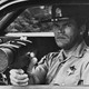 A police  officer uses a radar gun through a window of a car