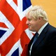 Boris Johnson walks past the flags of the United States and the United Kingdom.