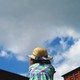 A girl looking at the sky, seen from behind