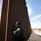 A U.S. Border Patrol agent looks through the U.S.-Mexico border fence in Santa Teresa, New Mexico.
