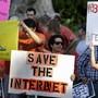 Activists hold signs at a rally for network neutrality.