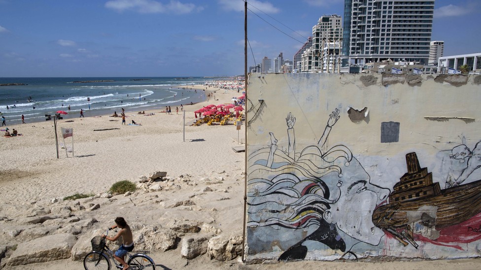 A boy rides a bike on Tel Aviv's beach front.